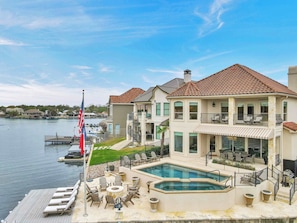 A waterfront property with a pool, outdoor seating, and a flagpole. - Diagonal Dreams Lake House | Concierge Services (Horseshoe Bay)