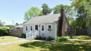 A single-story house with a front porch, a chimney, and a small front yard. - Adorable two bedroom sleeping 6 in West Dennis, .6 miles to the beach! (West Dennis)