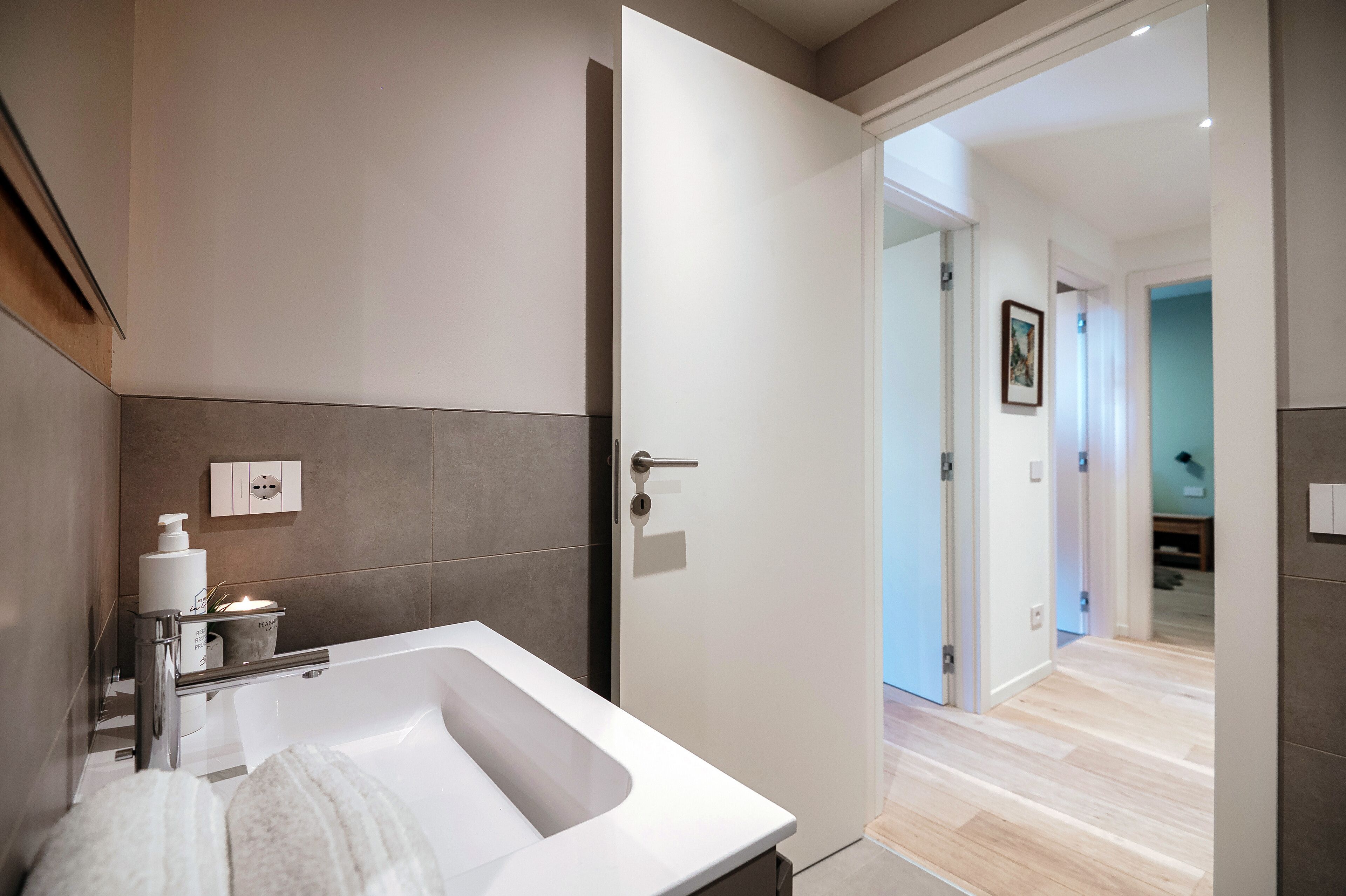 Une salle de bain moderne avec une grande baignoire, un porte-serviettes et une petite étagère contenant des articles de toilette.