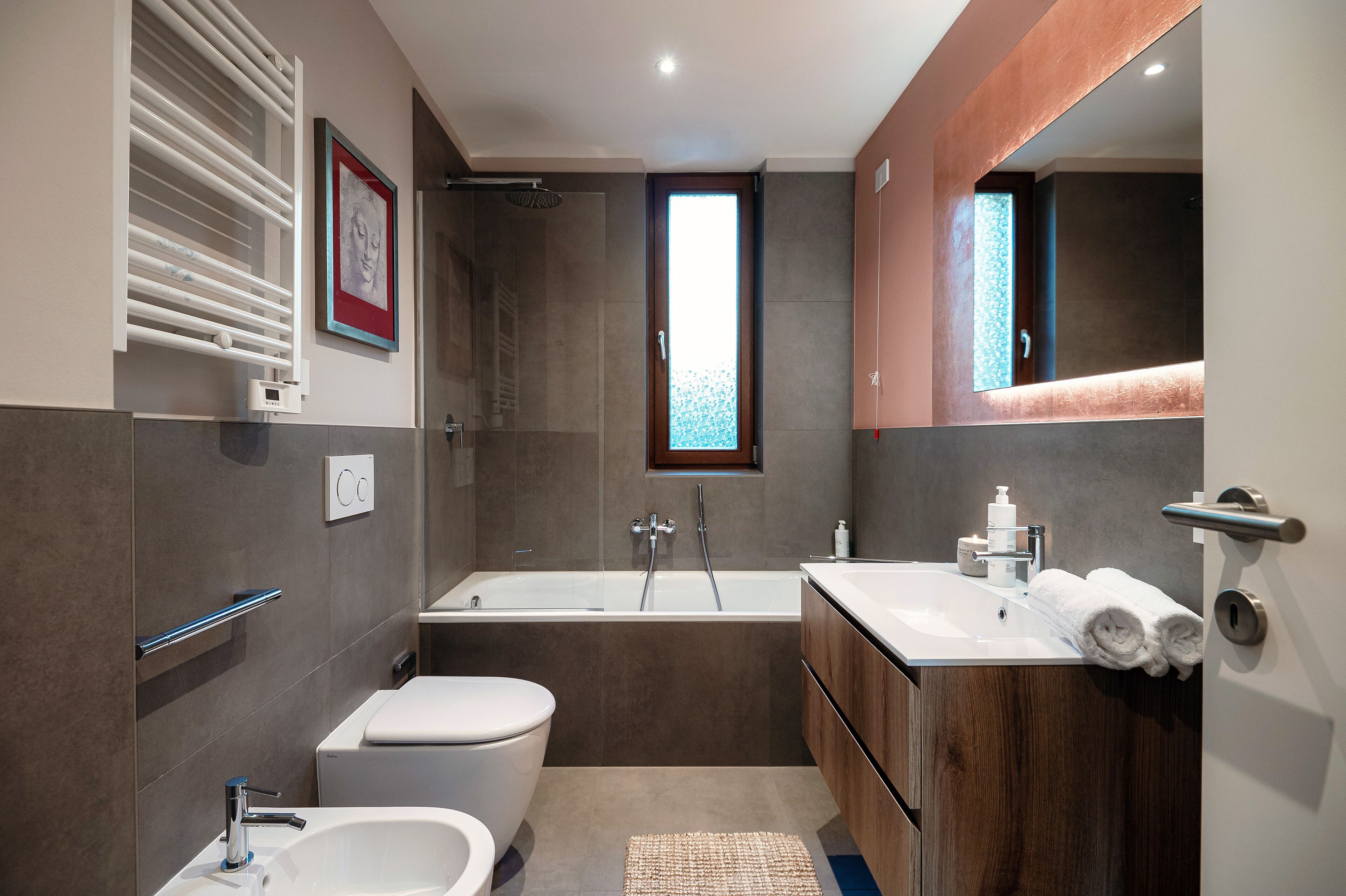 Uma casa de banho moderna com banheira, sanita e lavatório.