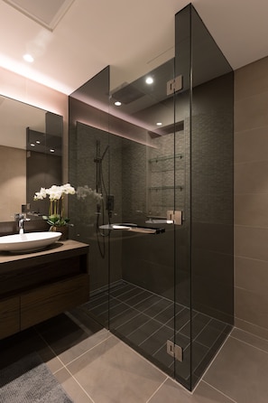 A modern bathroom with a glass-enclosed shower, a vanity with a sink, and a mirror. - Sunny 2BR at Jumeirah Living Marina Gate (Dubai)