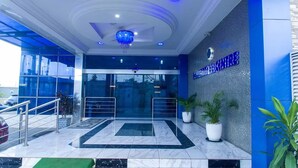 A hotel entrance with a blue and white color scheme, a chandelier, and potted plants. - MountRoyal Centre Hotel and Suites (Lagos)