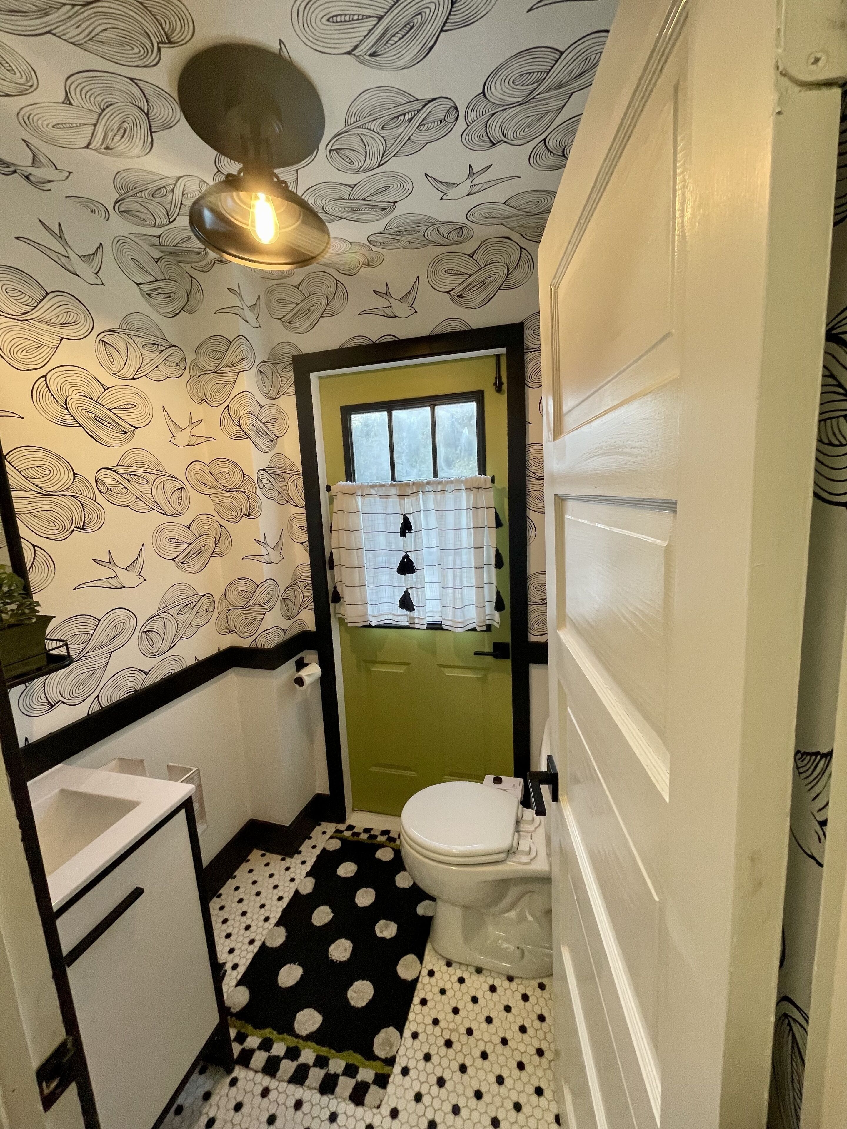 Een kleine badkamer met toilet, wastafel en een vloer met patroon.