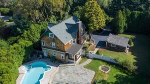 A large house with a swimming pool, a separate garage, and a well-maintained lawn. - Chester County Oasis with Pool, Modern Ammenities, Tranquil and Private (West Chester)