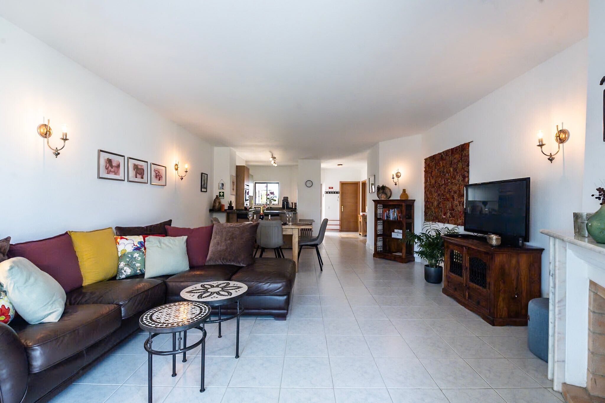 Un salon moderne avec un canapé, une table basse, un téléviseur et une cheminée.
