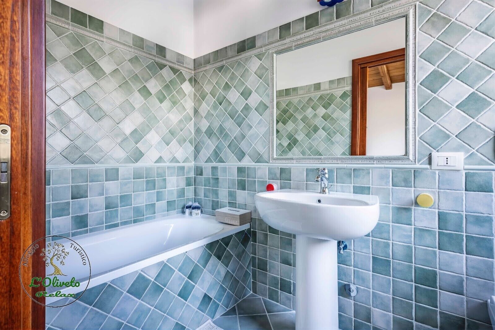 A bathroom with a bathtub, a sink, and a mirror.