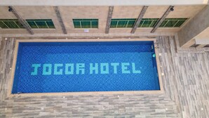 Una piscina con las palabras "JOGOR HOTEL" grabadas en los azulejos.