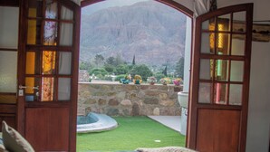 Un dormitorio con vistas a un paisaje montañoso a través de puertas abiertas.