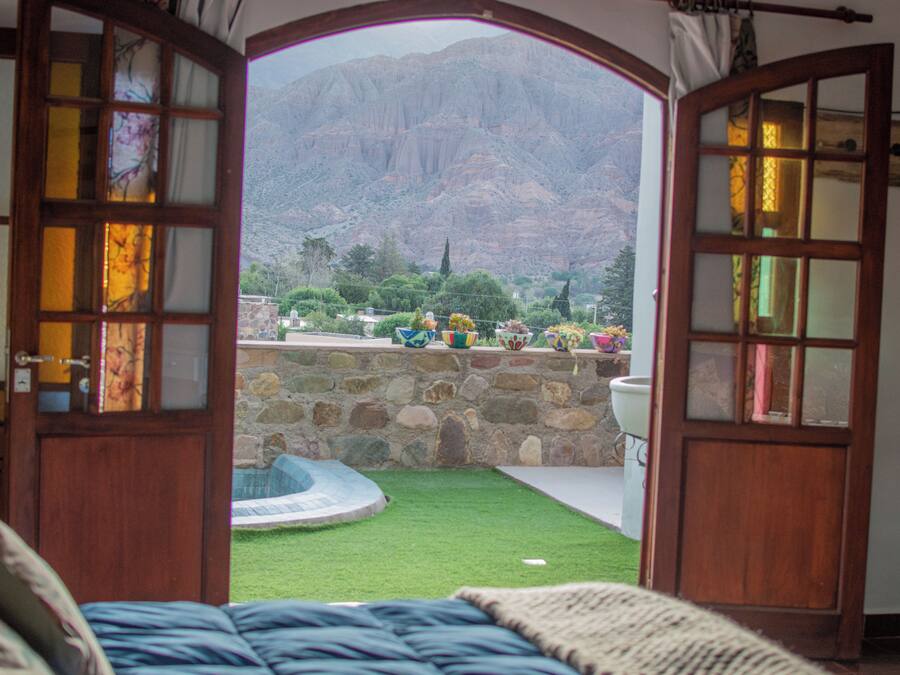 A bedroom with a view of a mountainous landscape through open doors.