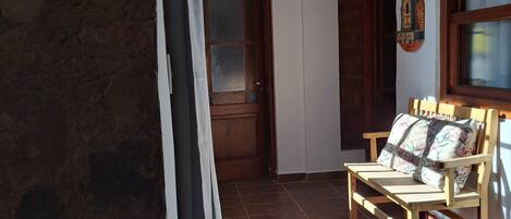 A room with a wooden bench, a hanging lantern, and a door with a frosted glass panel.