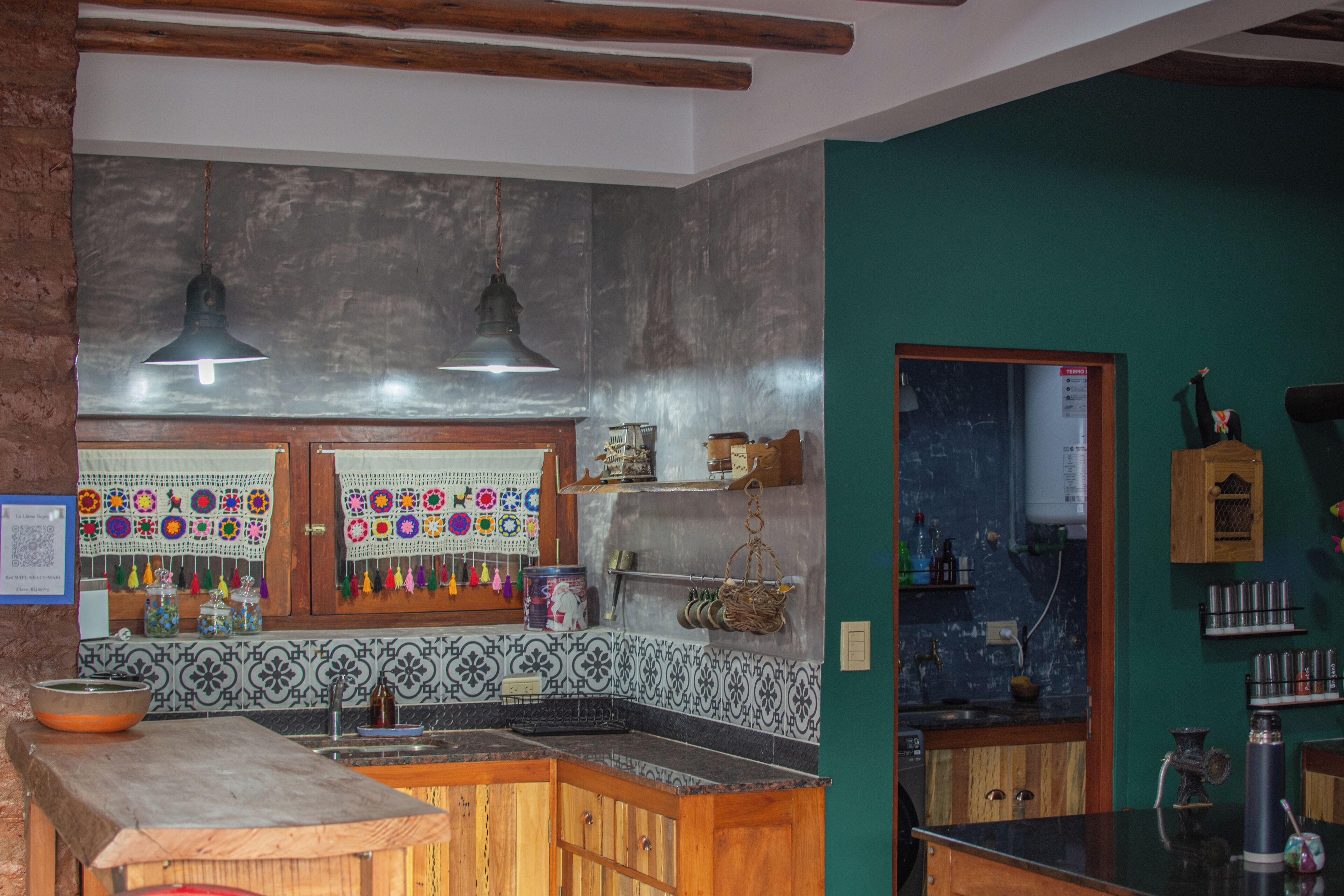 A kitchen with wooden cabinets, a sink, and hanging crochet decorations.