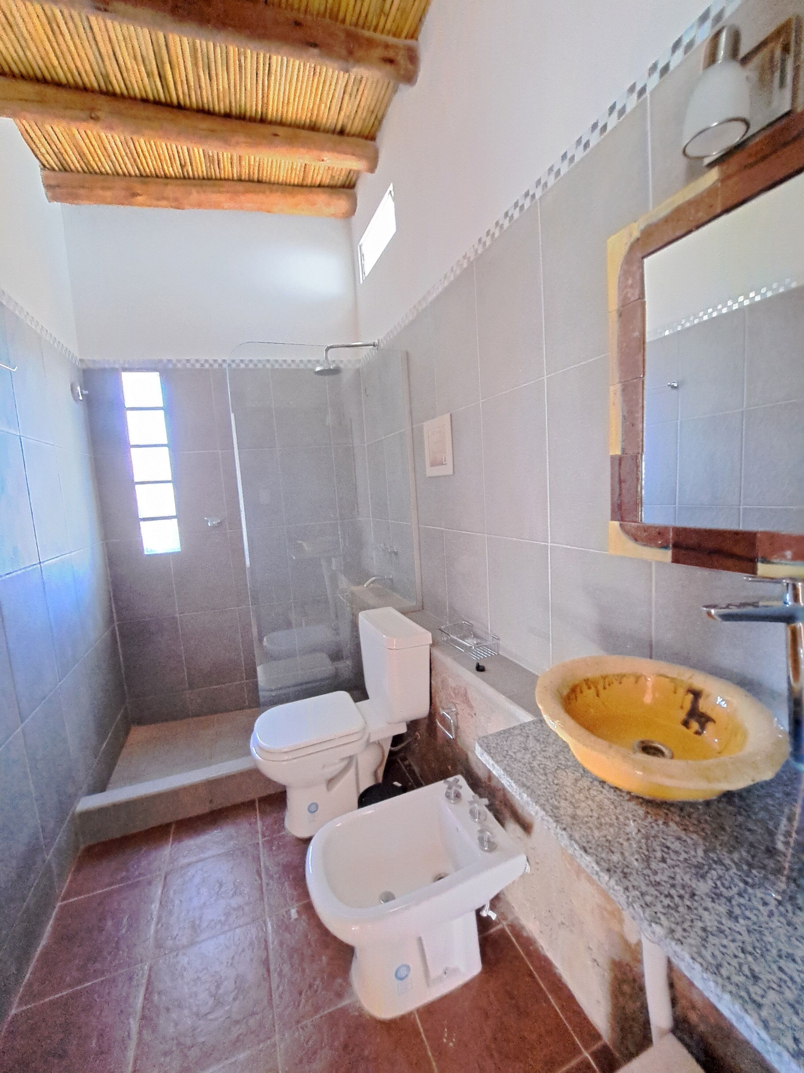 Een badkamer met douche, toilet, wastafel en bidet.