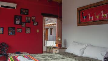 Una habitación con una cama, una ventana, una pared decorada con cuadros y un cuadro.