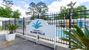 A sign for The Iconic Island Villa with a pool and palm trees. -  Sports Weekend Stay Near Fields, Beach & Pool onsite. Coffee/Wine in backyard (Gulf Shores)