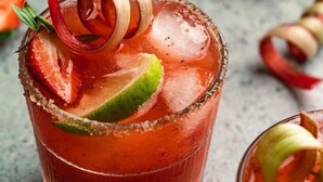 Ein Cocktail mit Salzrand, garniert mit einer Limettenscheibe und einem dekorativen Zwiebelring.