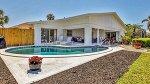 A modern house with a swimming pool, outdoor seating, and a fenced backyard. - RENOVATED 4/3 Canal Front, Pool and Dock (Longboat Key)