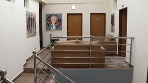 A hotel lobby with a staircase, a sofa, and artwork on the walls. - Paragon Gardens & Suites (Port Harcourt)