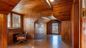 Ein Holzinterieur mit Schreibtisch, Stuhl, Fenster und Tür.