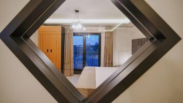Una habitación con cama, armario y vistas al exterior por una ventana.