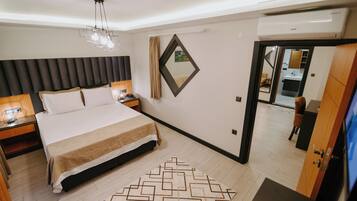 A modern hotel room with a large bed, bedside tables, a mirror, and a TV.