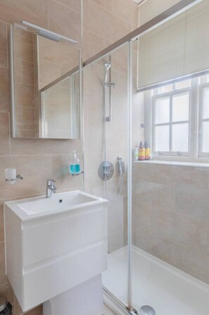 Apartamento básico | Banheiro | Chuveiro, toalhas de banho, sabonete, shampoo
