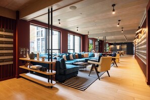 A modern living room with a blue sectional sofa, wooden shelves, and a striped rug. - Leeds Centre by Charles Hope (Leeds)