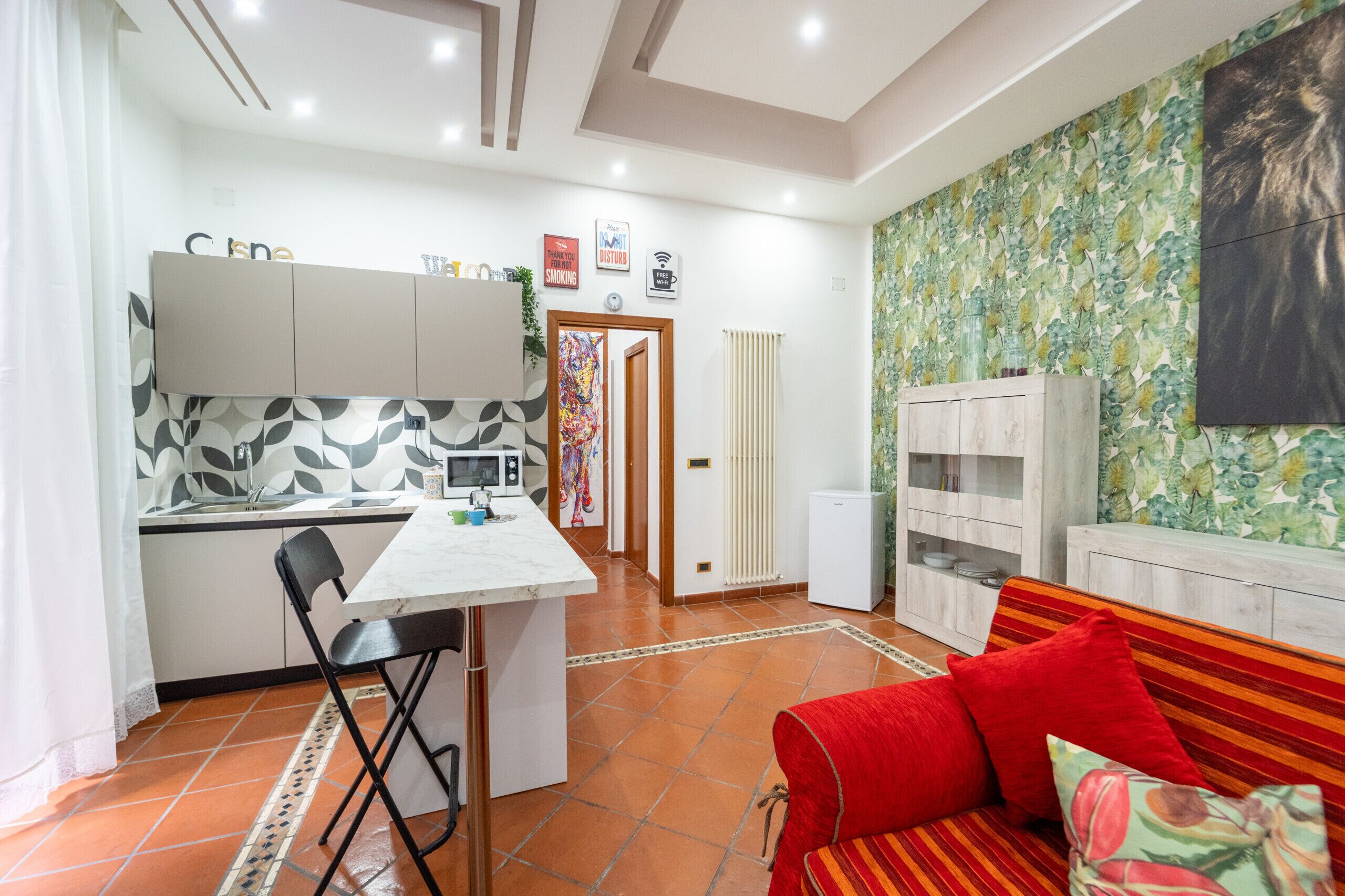 Un espacio habitable compacto con cocina, comedor y sofá.