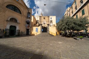 A historic building with a central entrance, stone steps leading up to it, and a clear sky above. - Rosaroll 70 Apartment by Wonderful Italy (Napoli)