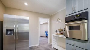 A kitchen with stainless steel appliances, a light blue cabinet, and a white countertop. - Pet friendly, huge fenced in yard, Fireplace, Firepit, near SGMC & VSU & Eats (Valdosta)