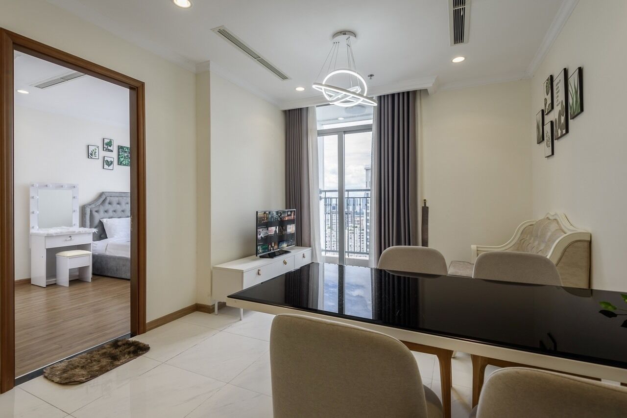 Quarto de hotel moderno com área de refeições, varanda com vista e quarto de dormir separado com toucador.