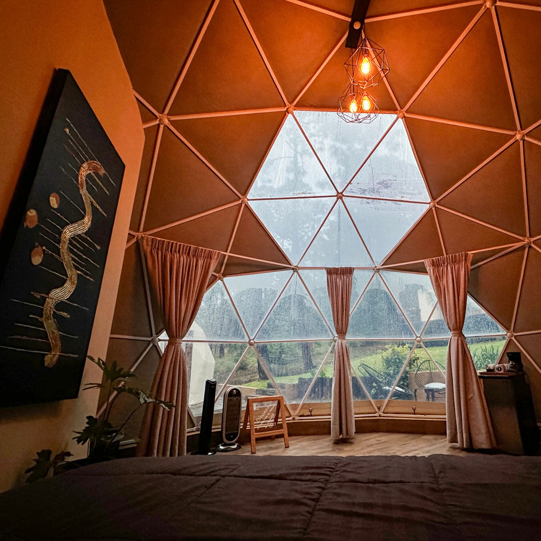 A room with a geometric ceiling design, large windows, and a bed.