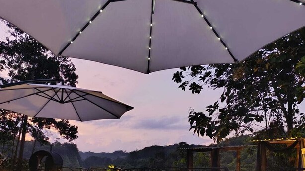 Un espace aménagé au bord de la piscine, avec des parasols, une terrasse et une vue sur le paysage.