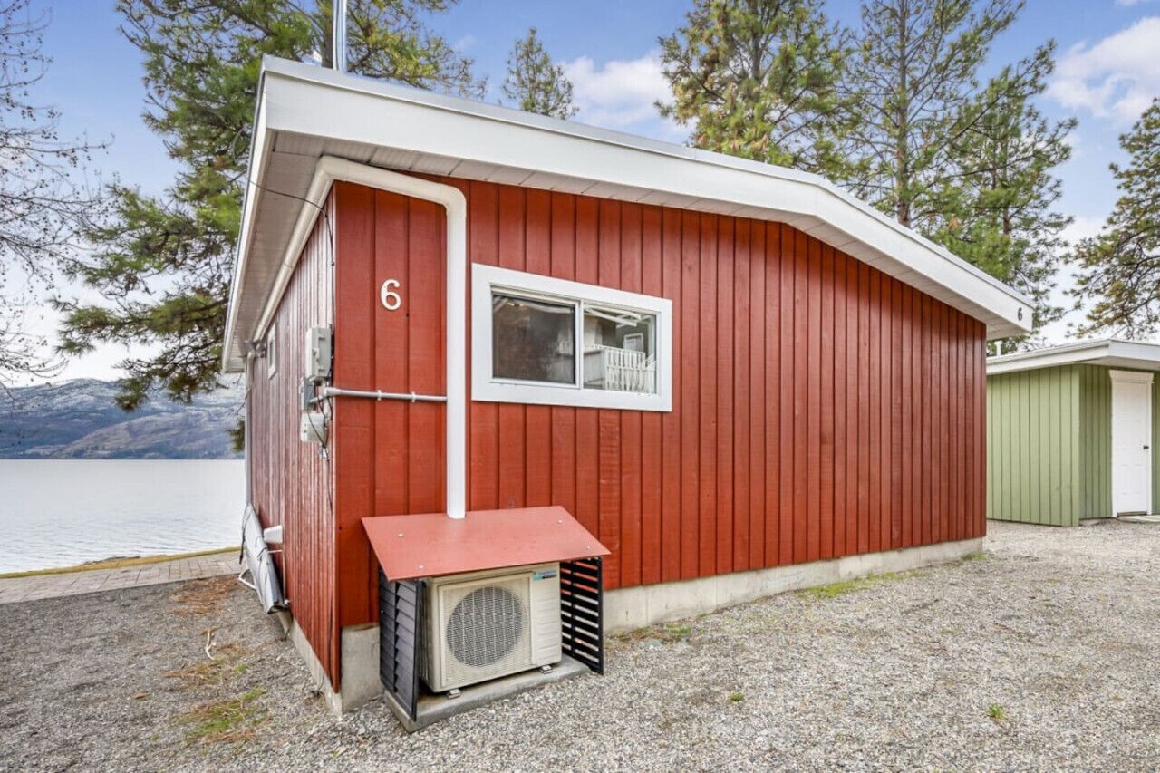 Un edificio rosso con una finestra e il numero '6' sulla porta.