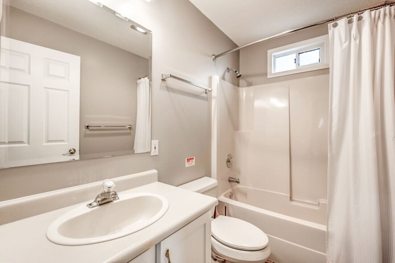 Un baño con lavamanos, inodoro y ducha.