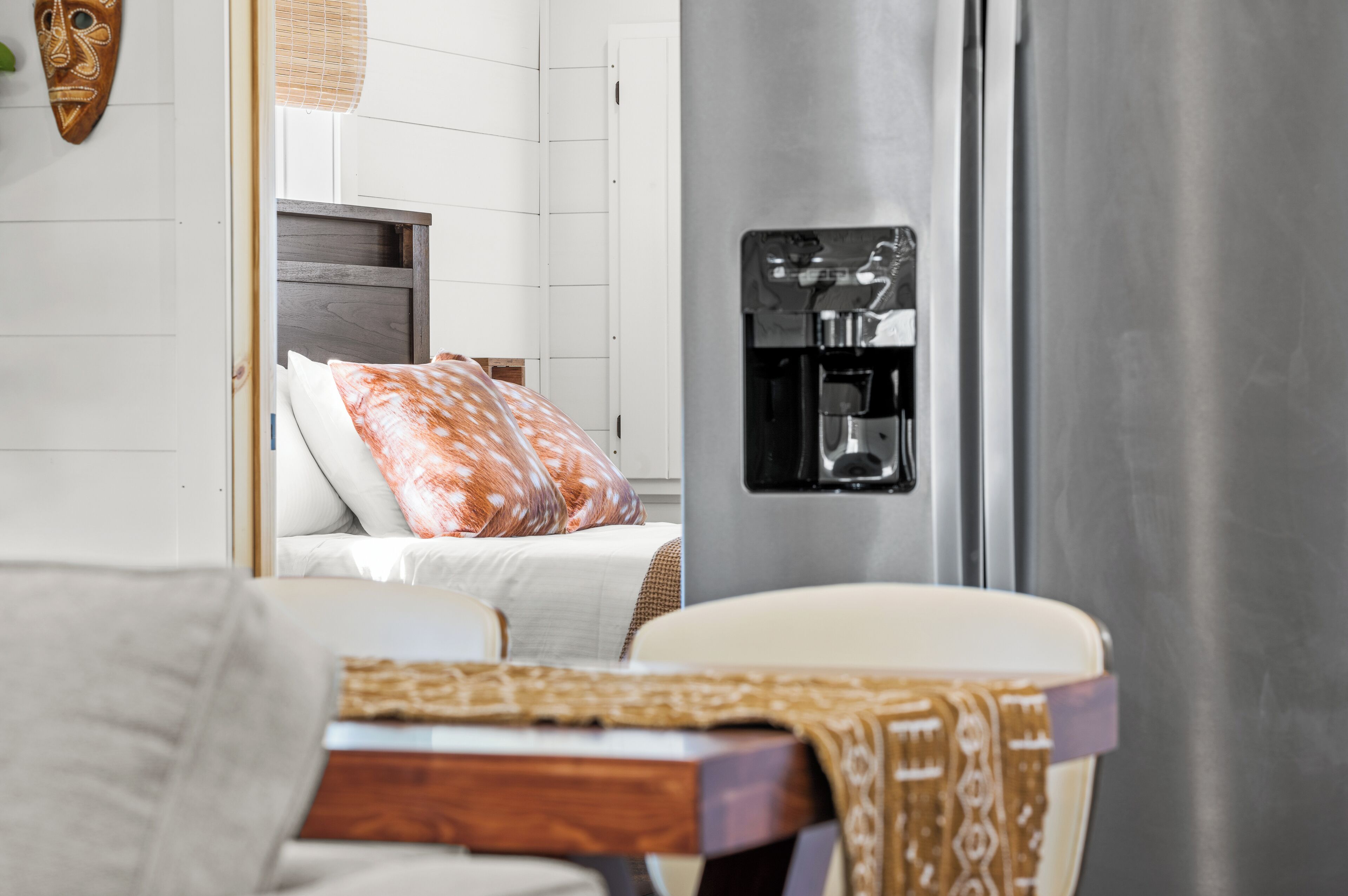 Une chambre d’hôtel équipée d’un lit, d’une machine à café et d’un distributeur d’eau fixé au mur.