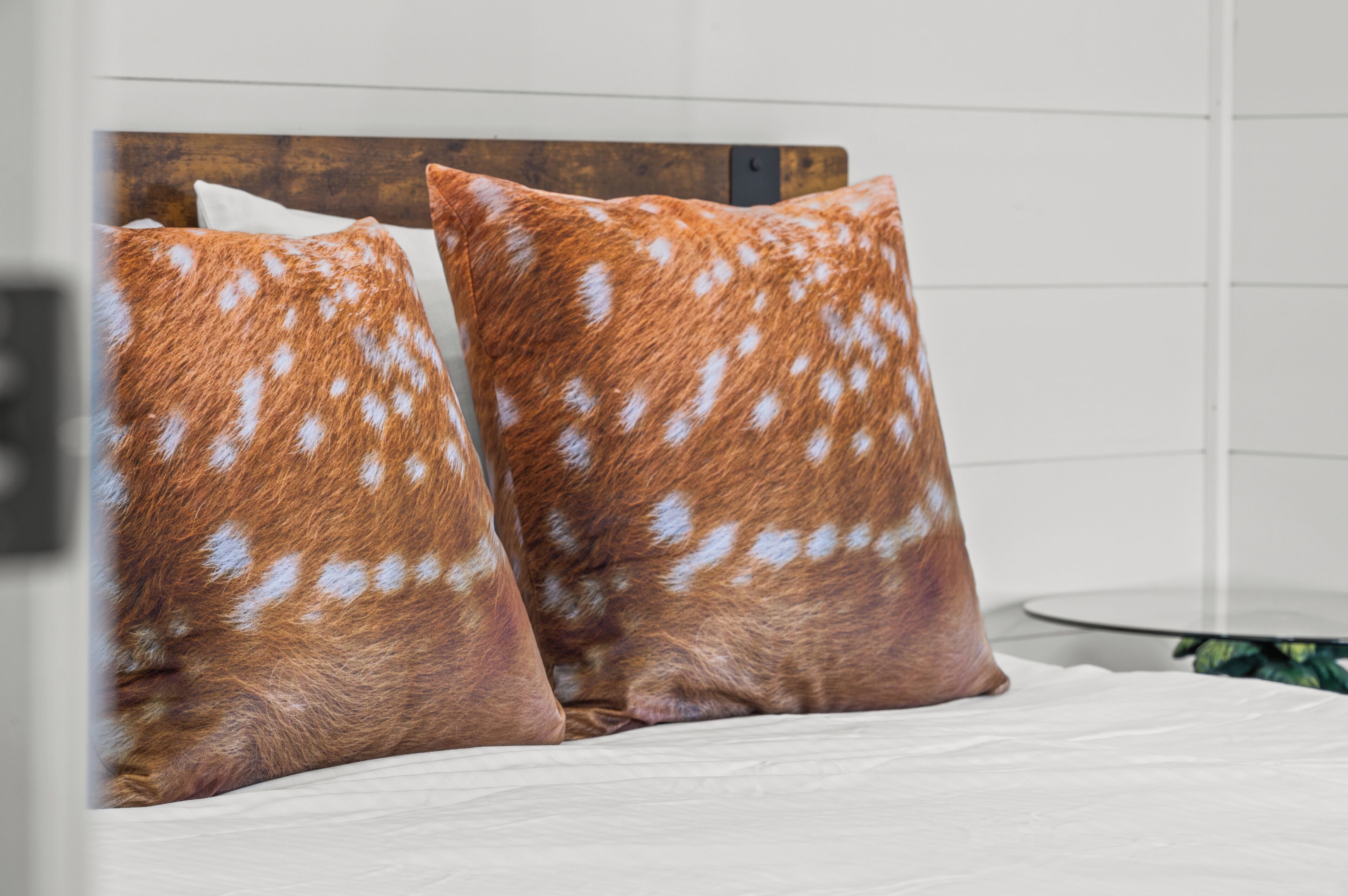 A bed with two pillows featuring a spotted pattern.