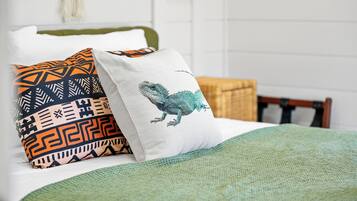 A bed with patterned pillows and a green blanket.