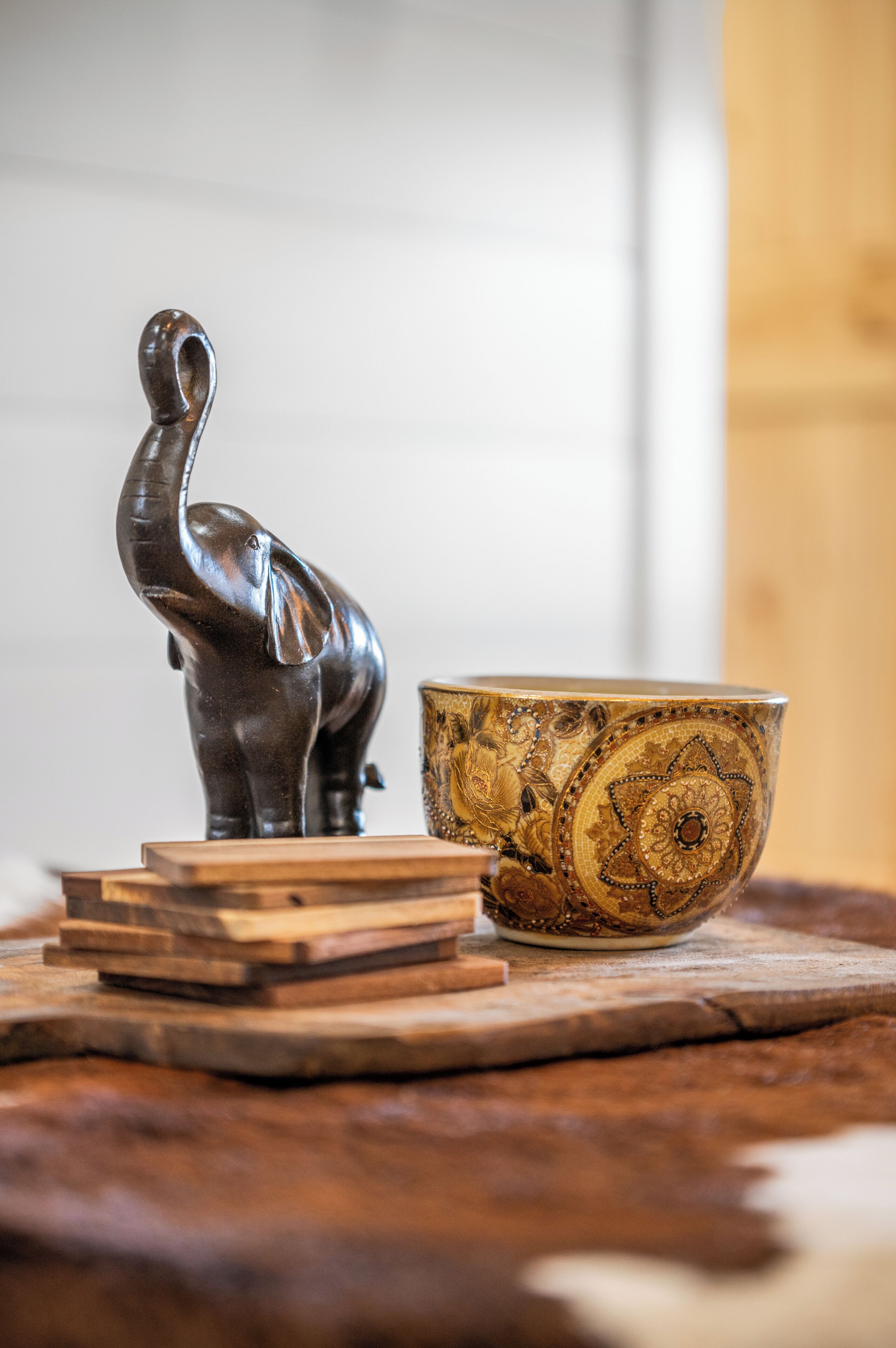 Une table en bois ornée d’une statuette d’éléphant décorative et d’un bol à motifs.