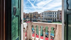 Un balcon offrant une vue sur des bâtiments historiques et un canal.
