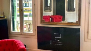 Et værelse med et stort vindue, en rød sofa og et fjernsyn, der viser en opdateringsbesked.