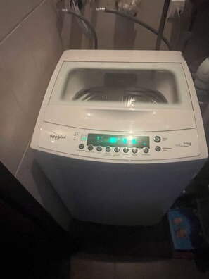 A front view of a Whirlpool washing machine with a digital display, control panel, and a 14kg capacity label. - Pura Vida Dreams (Tamarindo)