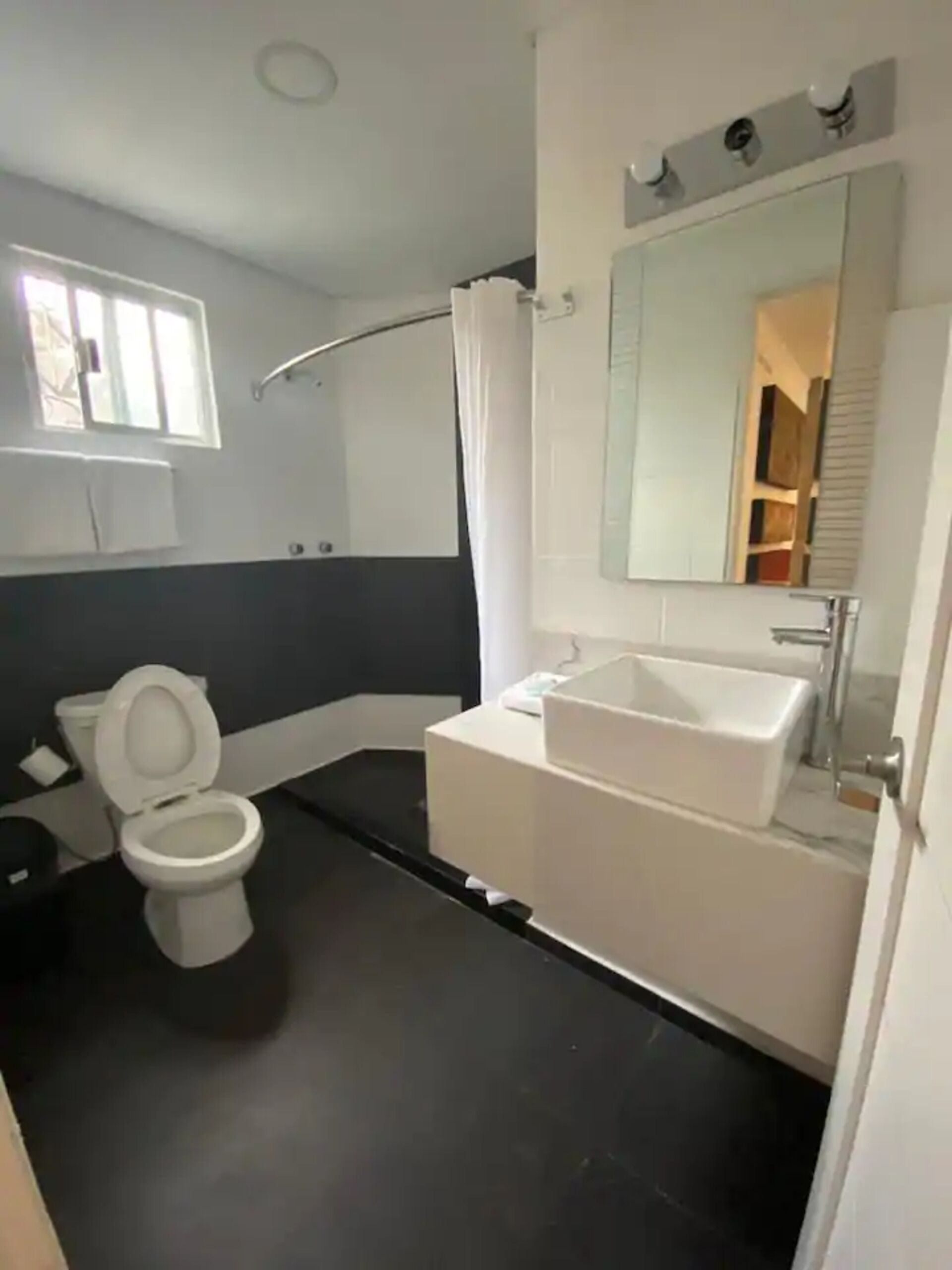 Une salle de bain moderne équipée de toilettes, d’un lavabo et d’une douche.