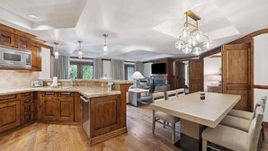 Una cocina amplia con armarios de madera, una isla central y un comedor con mesa y sillas.