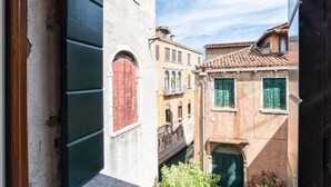 Un estrecho callejón flanqueado por edificios con diversos estilos arquitectónicos y un cielo despejado.