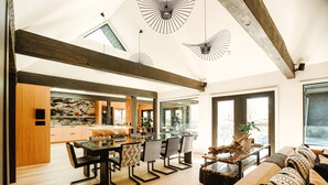 A spacious living area with a wooden dining table, patterned chairs, and a sofa with decorative pillows.