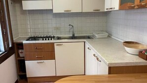 A kitchen with white cabinets, a sink, and a stove. - Jesuit Apartment (Venezia)