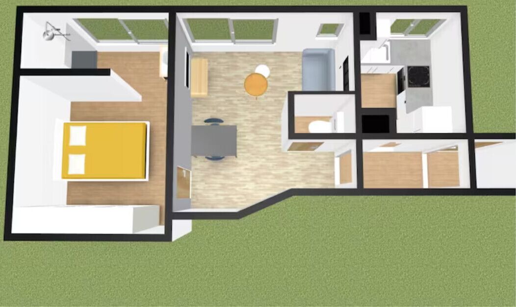 Plano de planta de una habitación de hotel con cama, escritorio, silla, mesita y sofá.