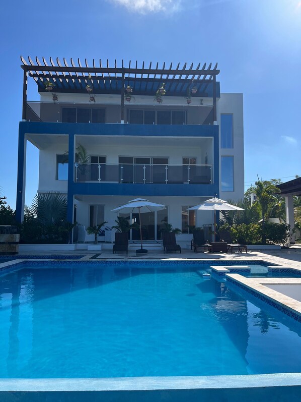 A modern two-story building with a swimming pool in front. - Luxury BeachFront Villa with Private pool and Ocean View!
(Punta Rucia)