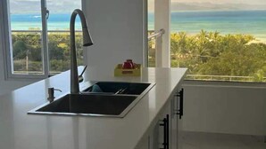 A kitchen with a large window, a sink, and cabinets. - Luxury BeachFront Villa with Private pool and Ocean View!
 (Punta Rucia)
