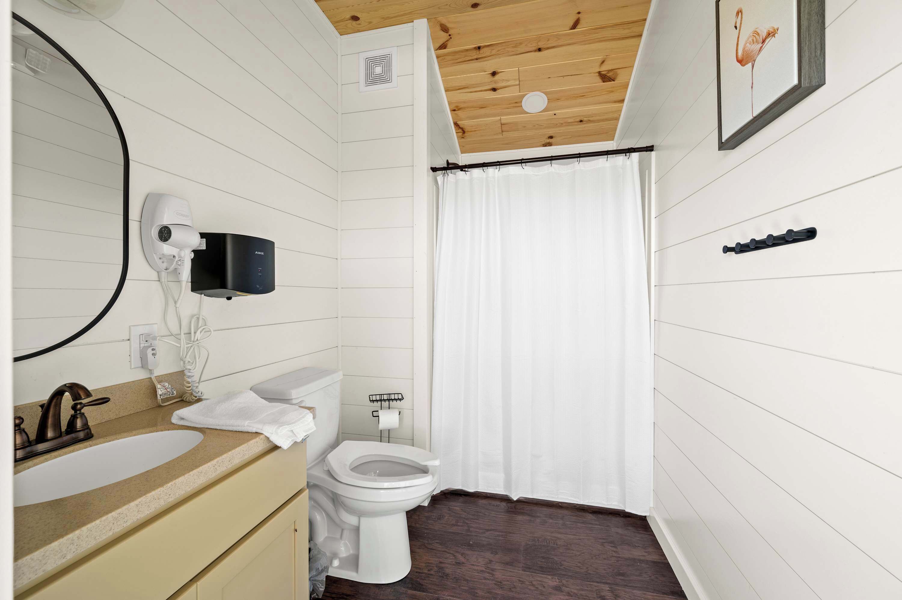 Ein Badezimmer mit Waschbecken, Toilette und Duschvorhang.